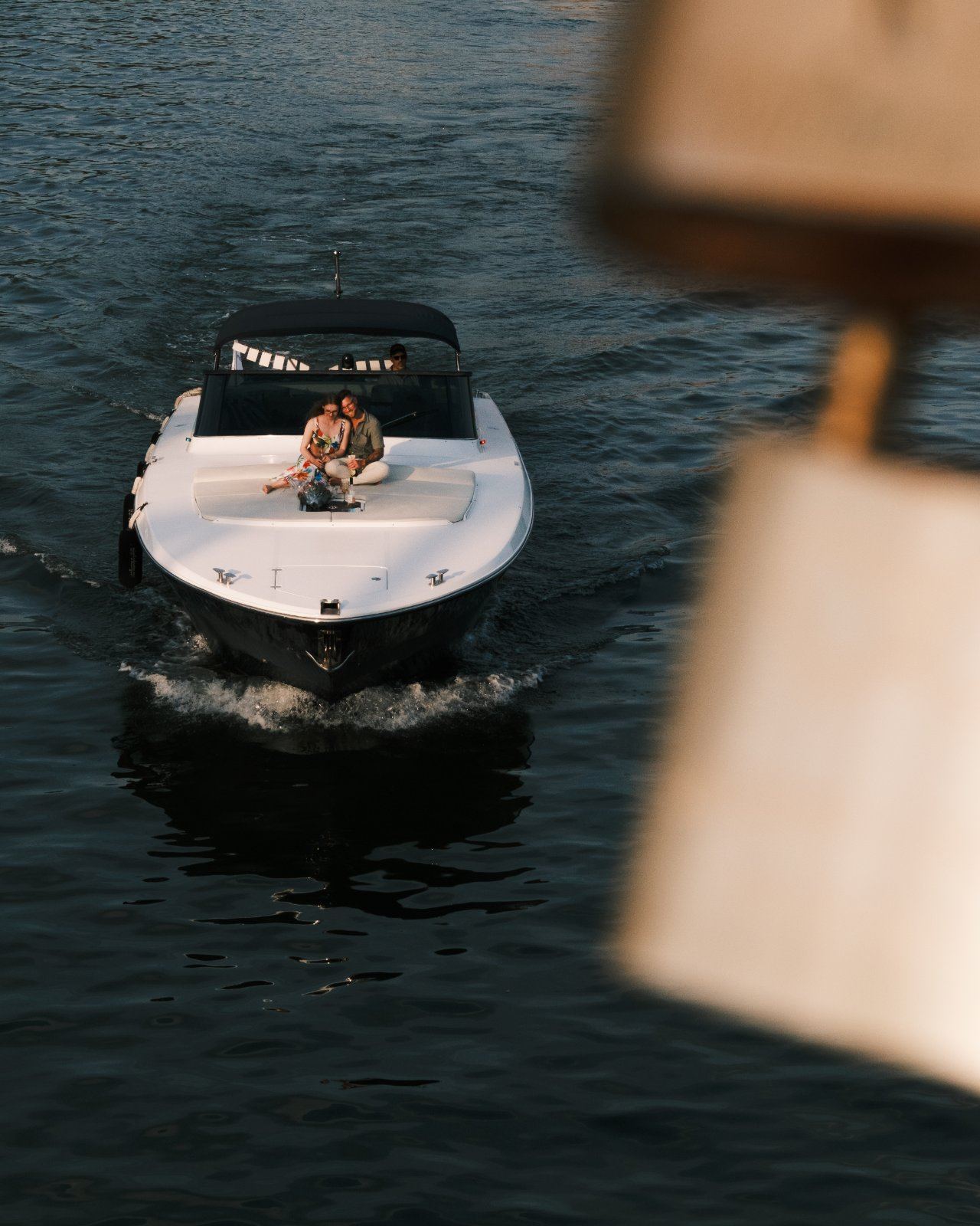 Pärchen sitzt auf einem Motorboot auf dem Main, fotografiert von einer Brücke aus